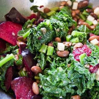 kale salad with pinto beans, cheese, and plums and balsamic dressing